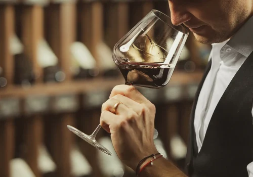 male-sommelier-tasting-red-wine-cellar copia
