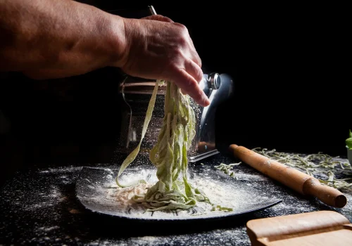woman-making-pasta-plate-with-kitchen-tools-black-background-horizontal-side-view copia